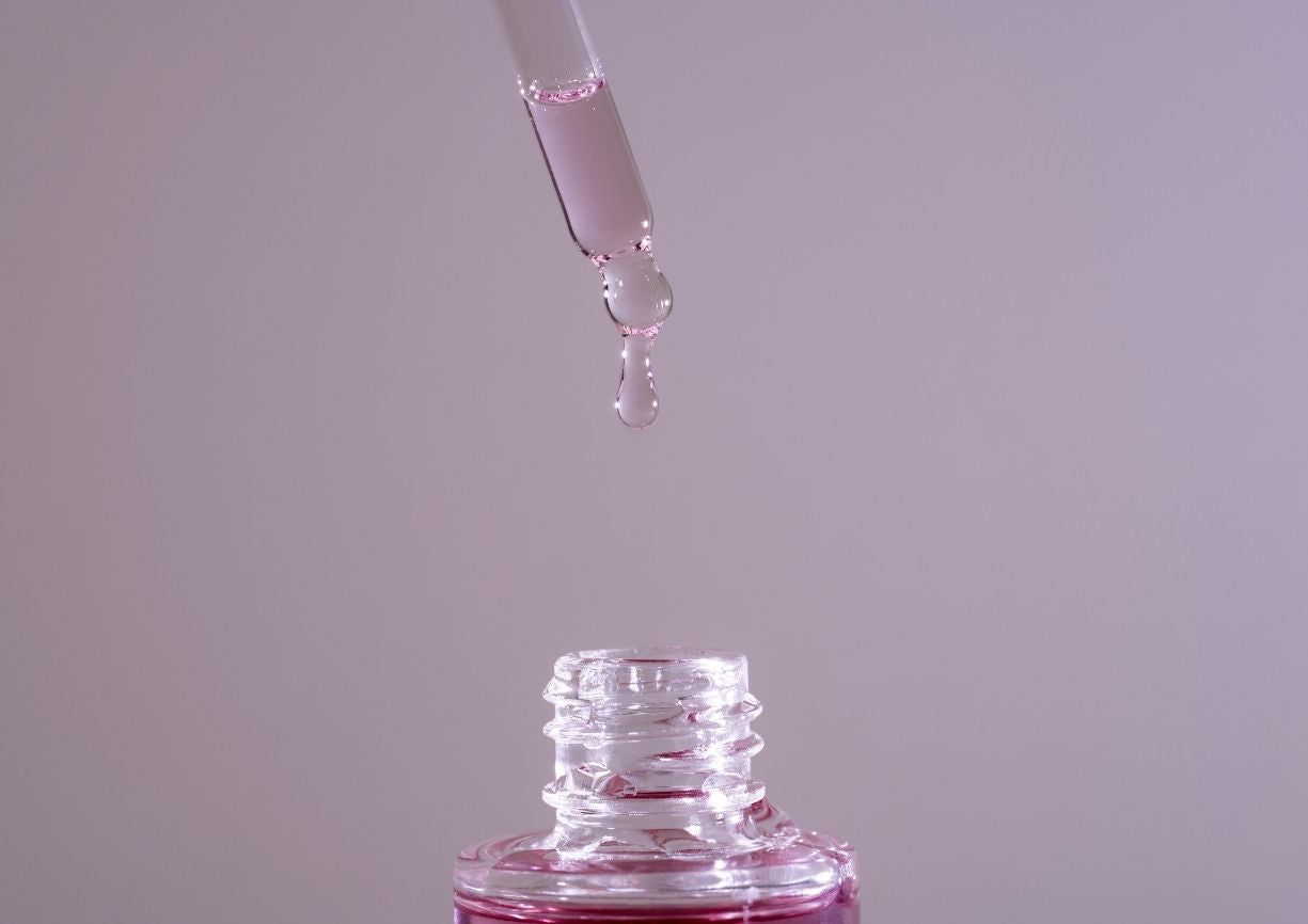 Image d'une pipette avec une goutte de sérum qui tombe dans le flacon