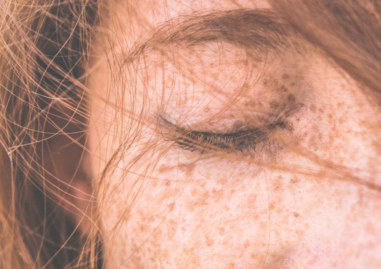 Visage d'une femme fermant les yeux sans maquillage, ni soins visage