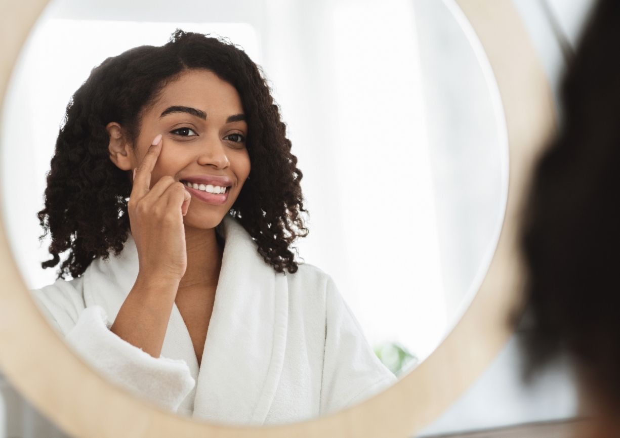 Femme se regardant le visage dans le miroir