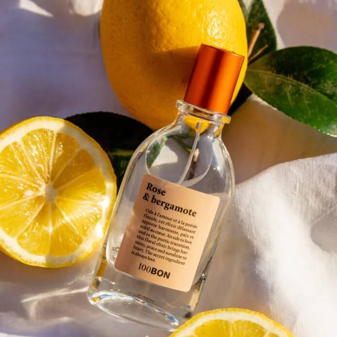 eau de cologne rose et bergamote posé sur un drap blanc et des citrons jaunes