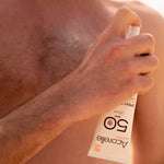 Spray solaire SPF50 acorelle applique sur le torse d'un homme