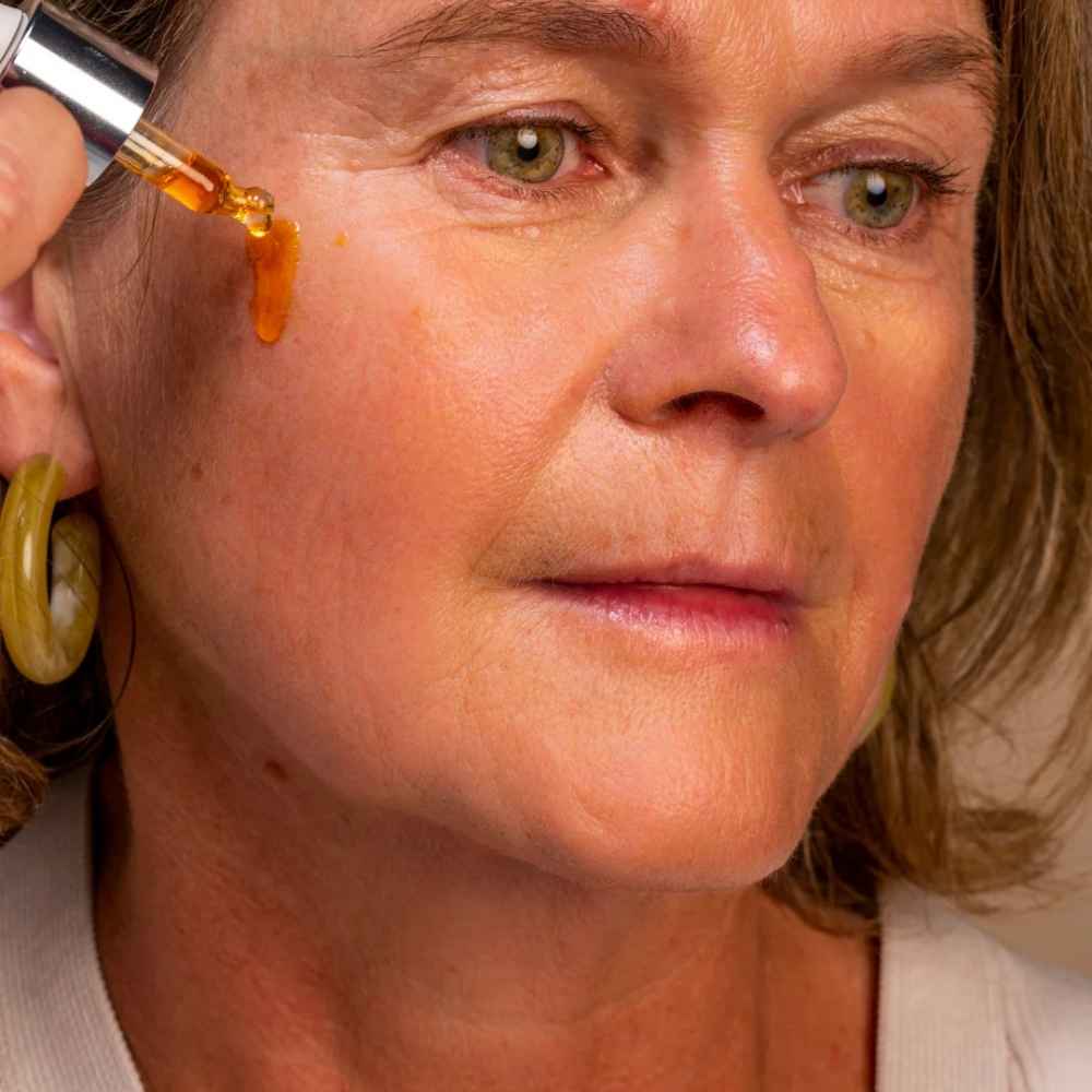 application sur le visage de l'huile vitaminée