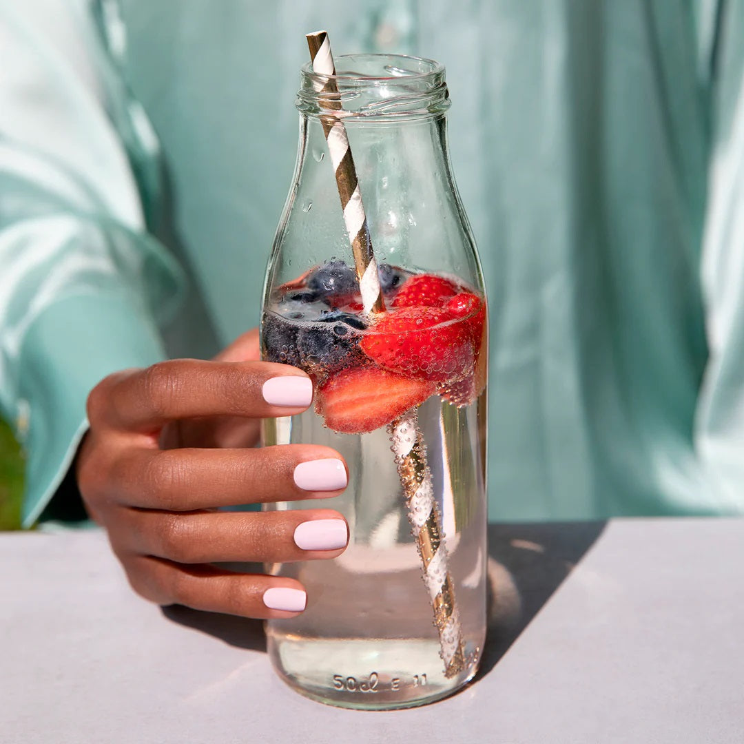 blossom manucurist vernis tenant une bouteille d'eau aux fruits