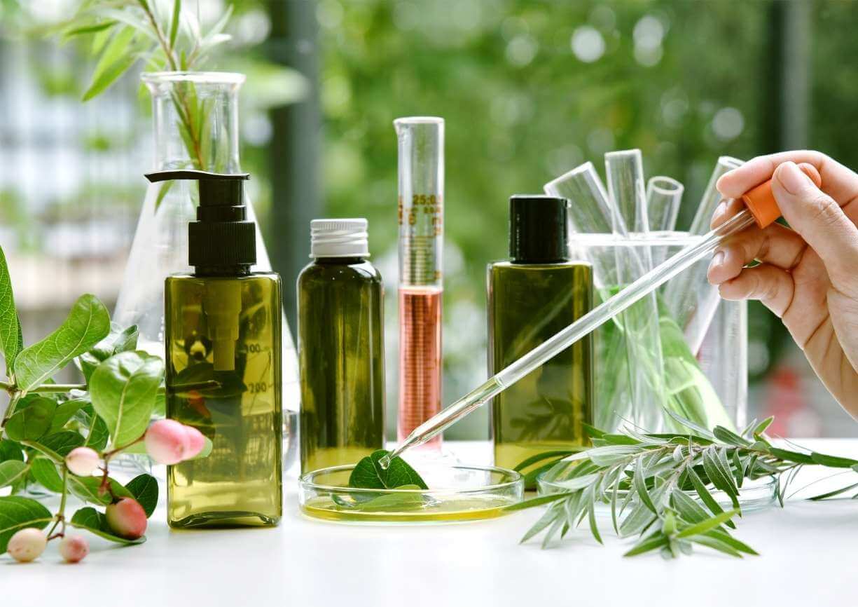 Confection de produits de beauté naturels avec des contenants vides, des plantes, une pipette et des tubes à essai