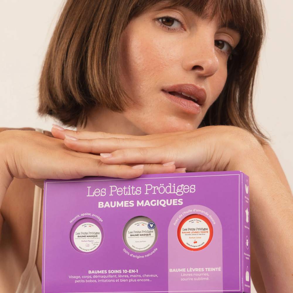Femme tenant le coffret Baumes Magiques Les Petits Prödiges, trois soins multi-usages en mini format voyage