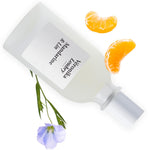 Flacon Mandarine & Lin Veronika Loubry entouré de quartiers de Mandarine et d'une fleur de Lin bleue