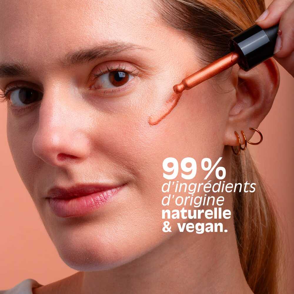 Application du blush liquide Sérum blush soleil La Crique à la pipette sur la pommette, formule à 99 % d'origine naturelle et vegan