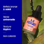 Flacon de Sérum blush soleil La Crique posé sur des feuilles d'Agave, blush liquide à reflets bronze et teinte universelle