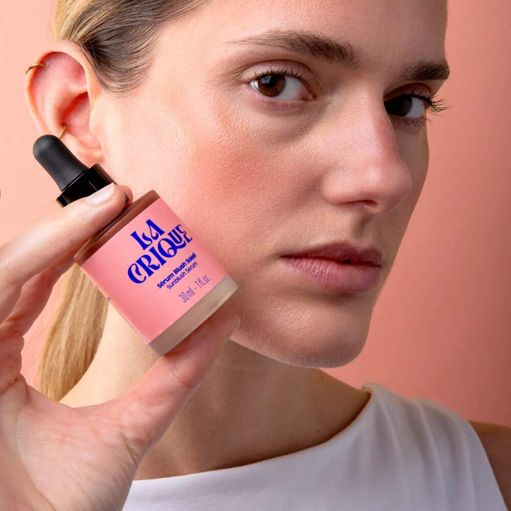 Femme tenant le flacon de 30 mL du Sérum blush soleil La Crique, joues à l'effet bonne mine naturel