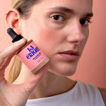Femme tenant le flacon de 30 mL du Sérum blush soleil La Crique, joues à l'effet bonne mine naturel
