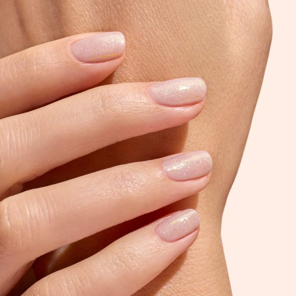 Rendu sur ongles nude et peau claire du Top Coat Pailleté Or Green Manucurist