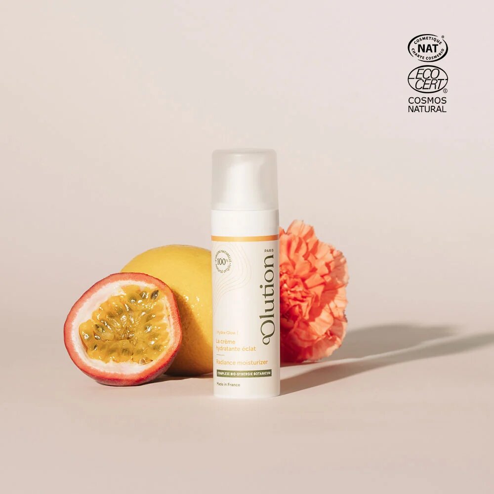 Crème hydratante éclat bio oOlution en flacon pompe de 30 mL, entourée d'un Fruit de la passion, d'un Citron et d'un Œillet, labellisée Cosmos Natural et Cosmébio