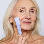 Femme aux cheveux blancs tenant le soin anti-âge contour yeux et lèvres Endro