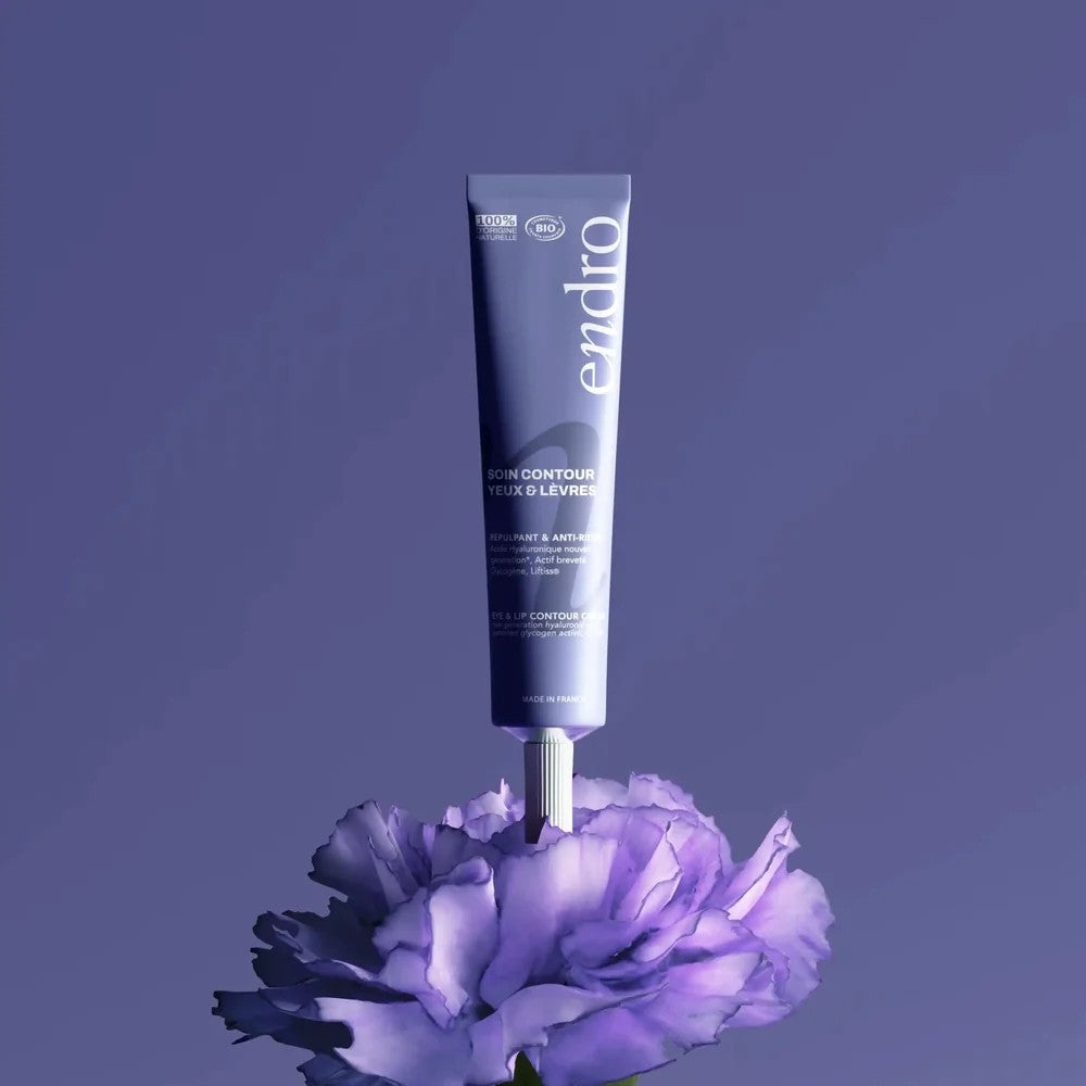 Tube du soin contour yeux et lèvres repulpant anti-rides Endro posé sur une fleur violette